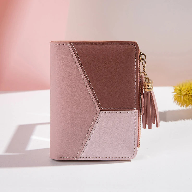 Two-tone pink wallet with a tassel on a light background