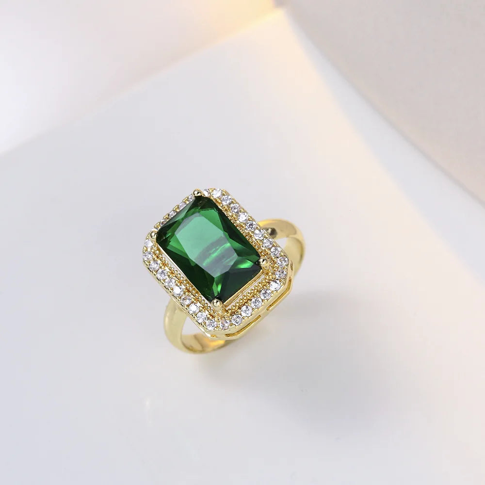 Gold ring with a green gemstone on a white background