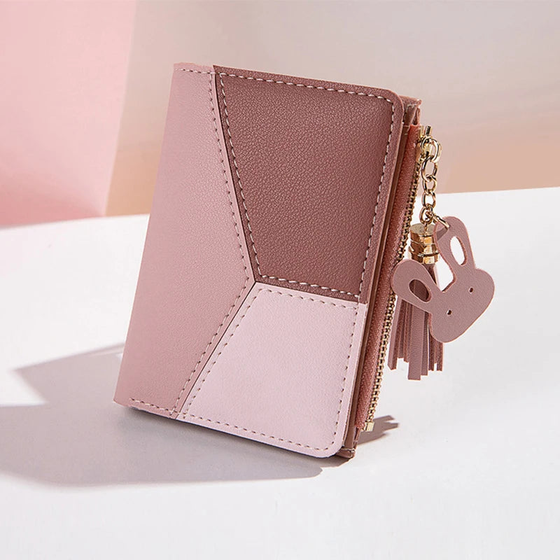 Pink and brown wallet with a keychain on a light pink background